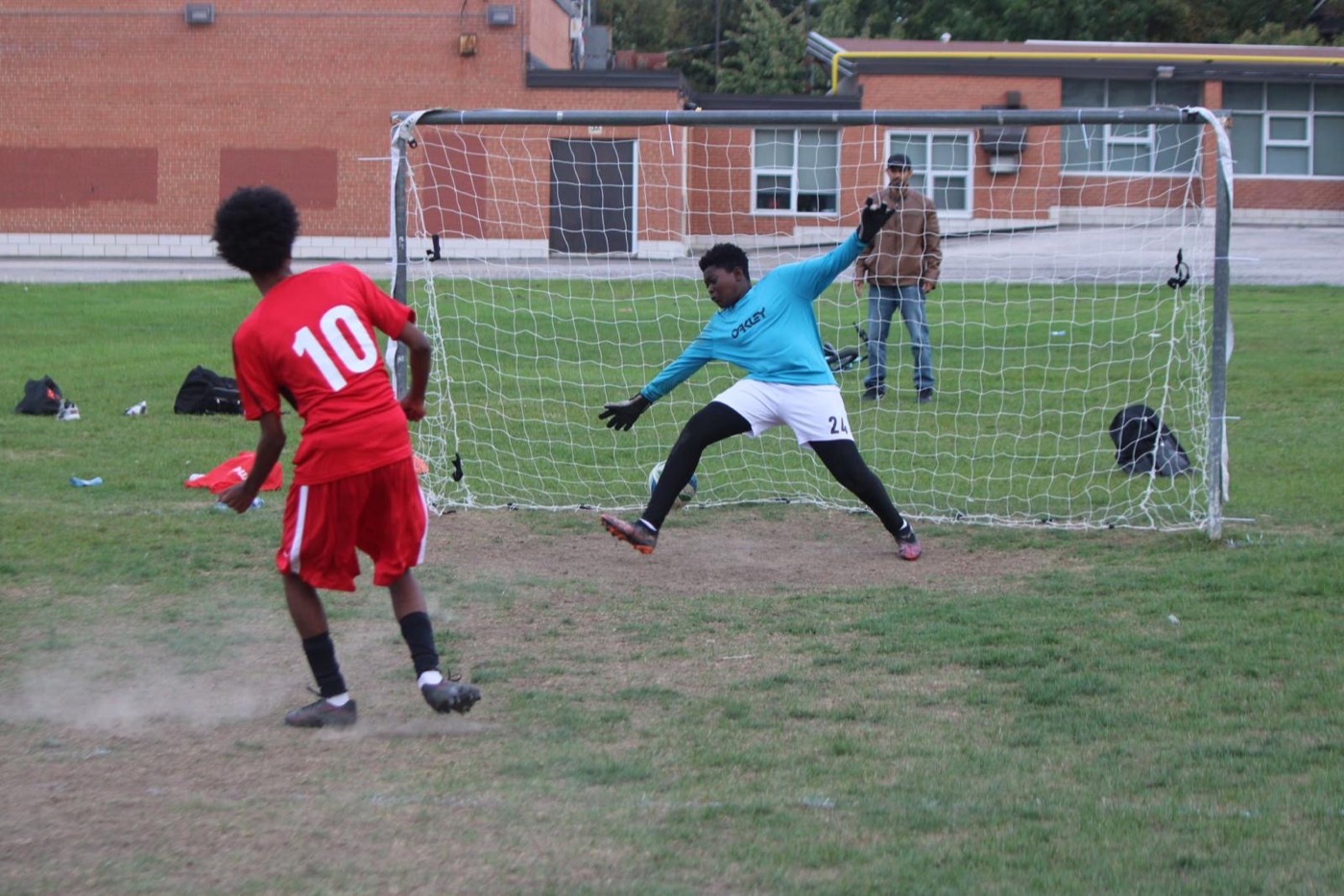 A goalkeeper dives as a player takes a penalty